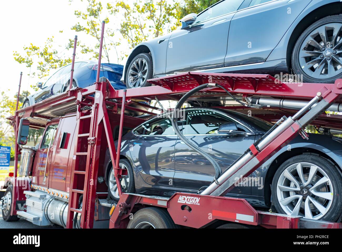 Toute nouvelle Tesla Motors voitures électriques, y compris le modèle 3 Tesla sur un camion transporteur de voitures en attente de livraison à proximité du siège social et usine de la Silicon Valley, Fremont, Californie, le 28 juillet 2018. () Banque D'Images