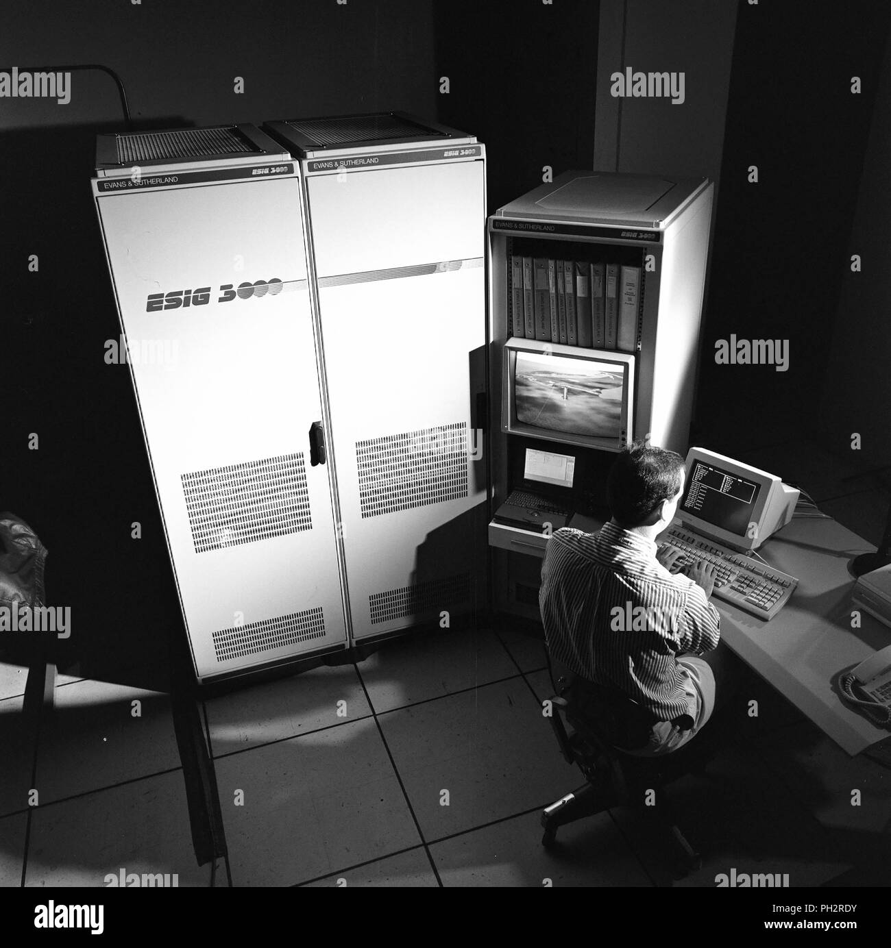 Photographie en noir et blanc de Chris Sweeney, de l'arrière, assis à la console de l'ordinateur de l'ESIG-300, qui est utilisé pour les machines virtuelles création graphique, photographié dans la Silicon Valley, Mountain View, Californie, le 19 novembre 1993. Avec la permission des Archives Internet/NASA Ames. () Banque D'Images