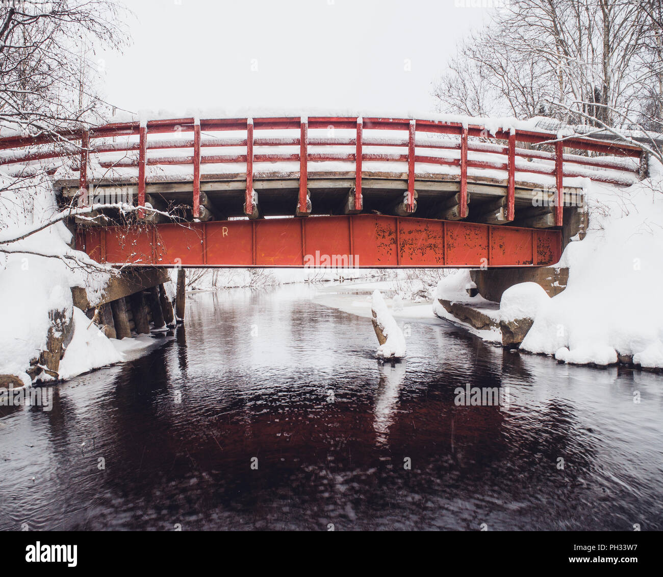 Vieux pont rouge en hiver, recouvert de neige Banque D'Images