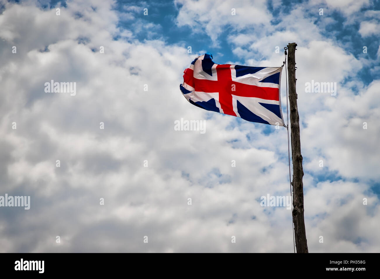 Une Union Jack britannique, probablement xvie siècle réplique, battant avec les nuages en arrière-plan. Banque D'Images