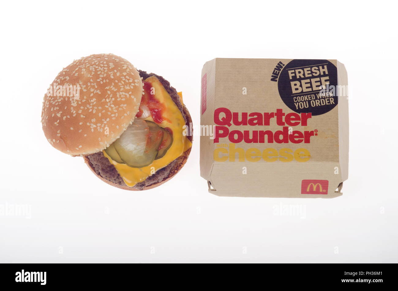 McDonald's le boeuf frais préparés à la demande du quart de livre avec fromage Cheeseburger avec fromage jaune, des cornichons, du ketchup et les oignons avec la boîte. Banque D'Images