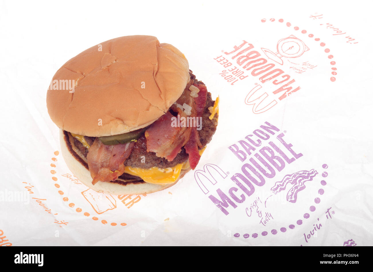 Bacon McDouble McDonalds Cheeseburger avec oignons, ketchup, le cornichon et fromage jaune sur l'emballage Banque D'Images