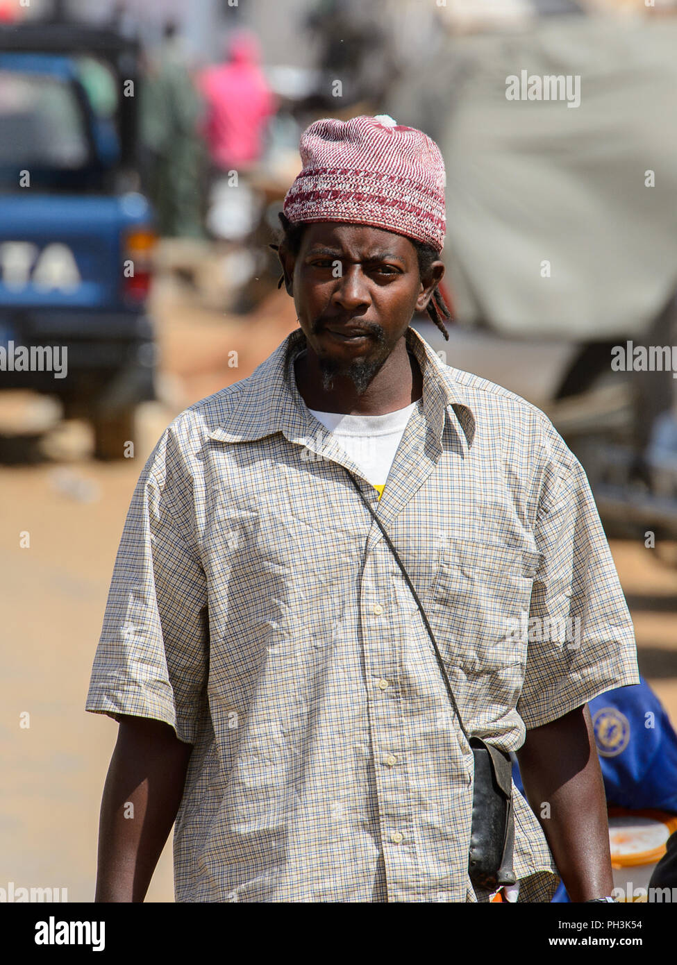 KAYAR, SÉNÉGAL - AVR 27, 2017 : l'homme sénégalais non identifiés avec  tresses en chemise grise et un chapeau d'agréables promenades le long de la  route au marché local de Kayar, Sene