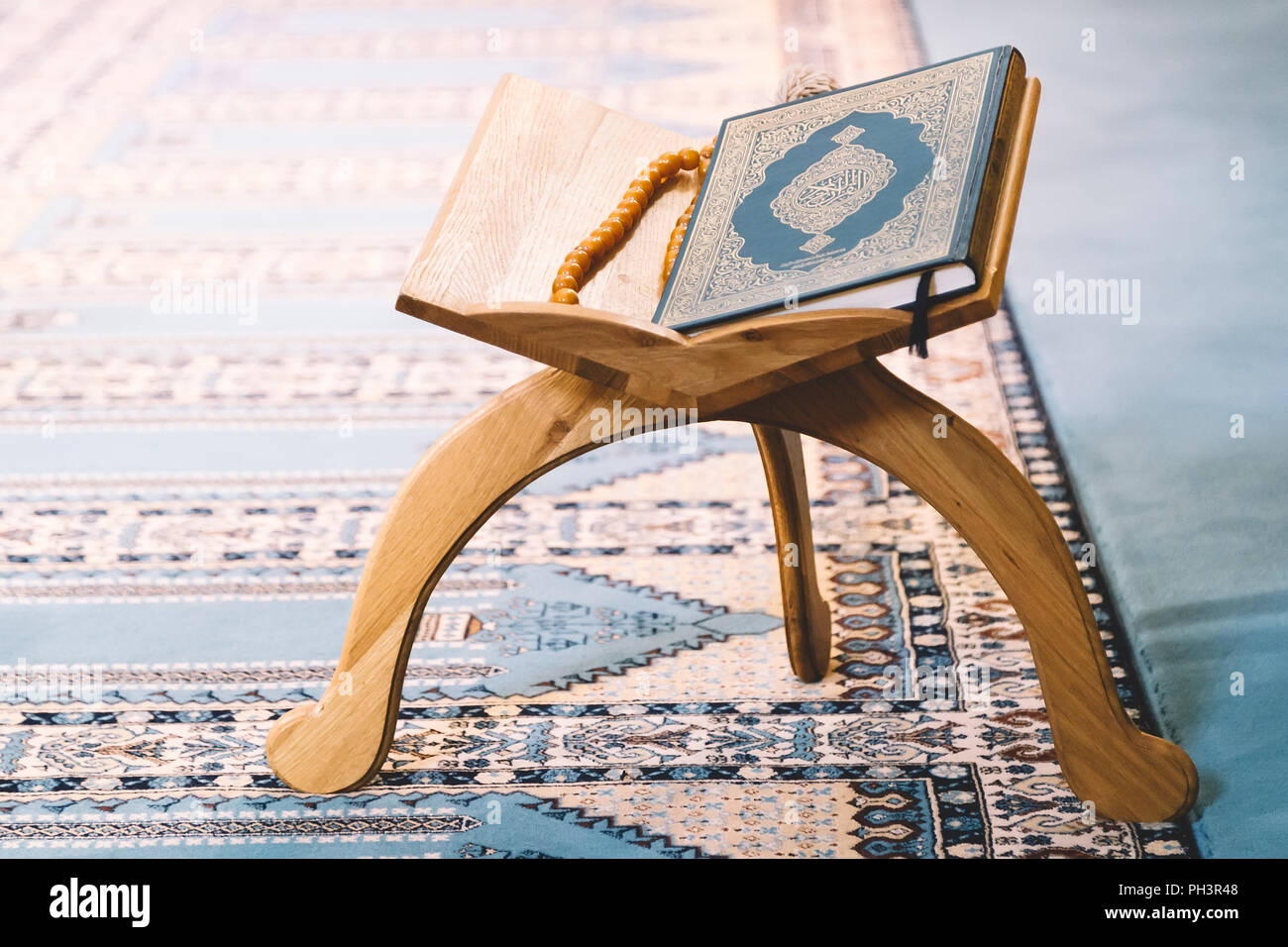 Le Coran, livre saint des musulmans à travers le monde, sur support en bois Banque D'Images