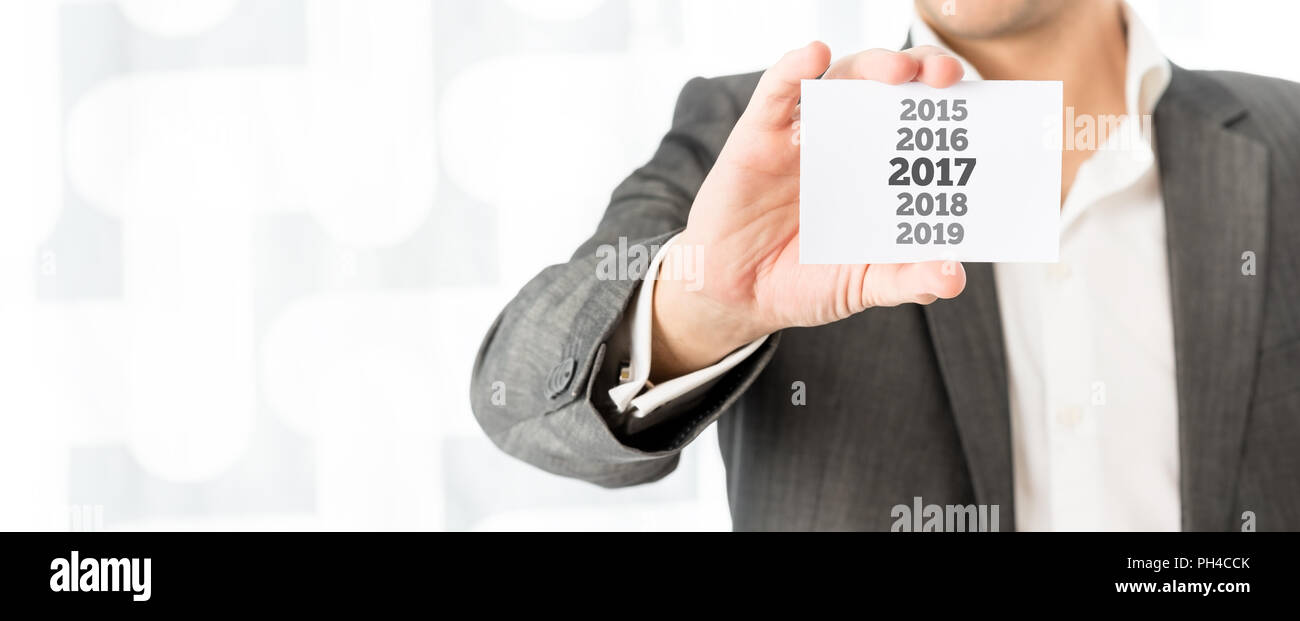 Businessman Celebrant La Nouvelle Annee 17 Tenant Une Carte D Affaires Avec Les Dates De L Annee 15 Jusqu En 19 Avec La Date De 17 En Caracteres Gras Copy Space Photo Stock Alamy