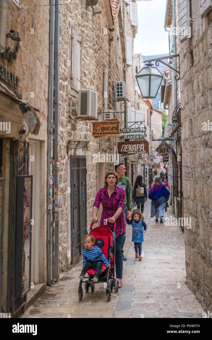 Budva, Monténégro - Avril 2018 : Mère et père, avec leurs enfants et buggy découvrez paris les rues étroites de la vieille ville de Budva Banque D'Images