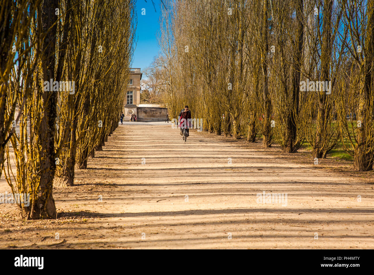 Couple riding a bicycle autour des jardins du château de Versailles dans un jour d'hiver gel juste avant le printemps Banque D'Images