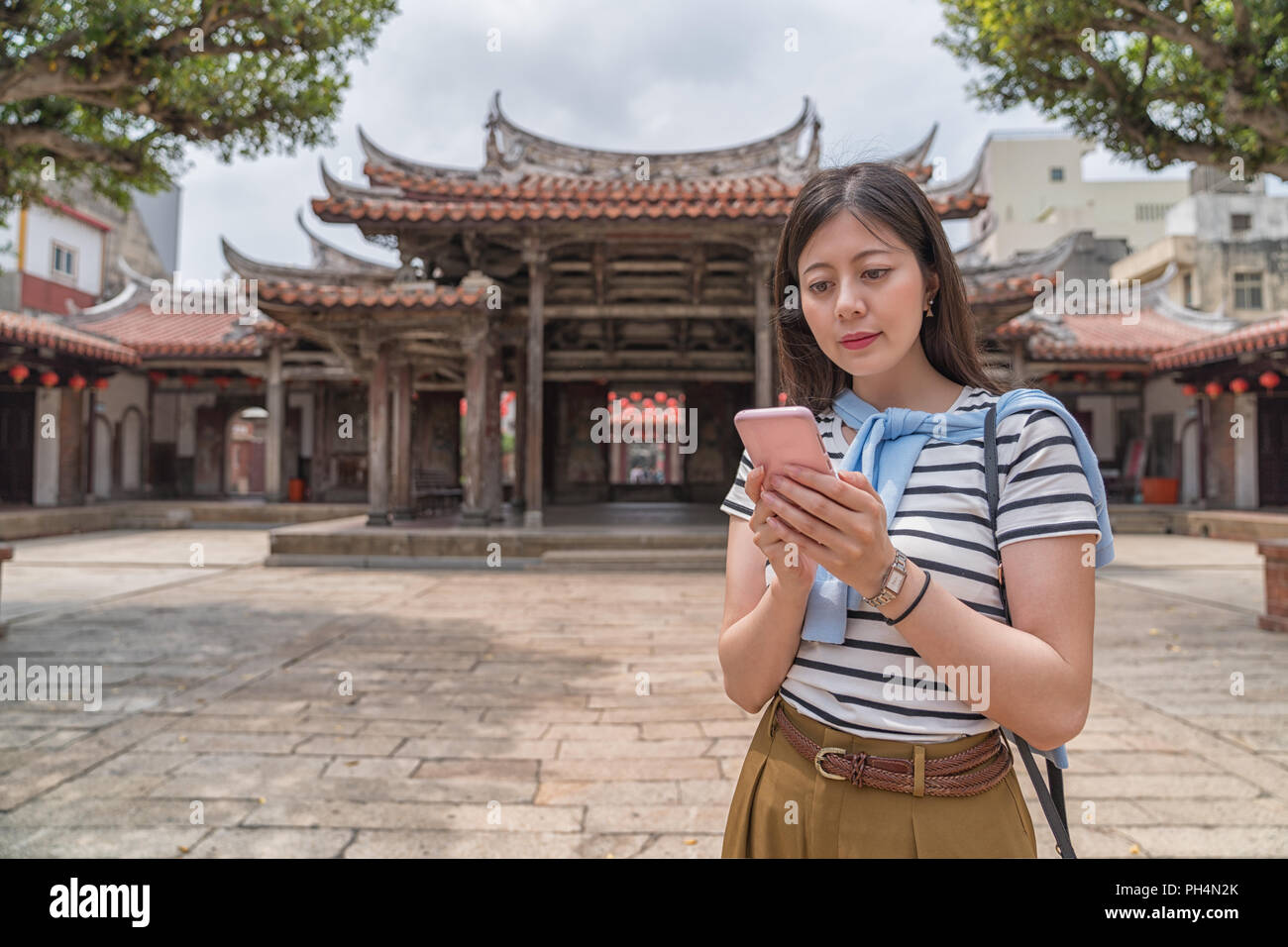 Recherche femme asiatique élégant par le téléphone. En essayant de trouver le prochain lieu. Banque D'Images
