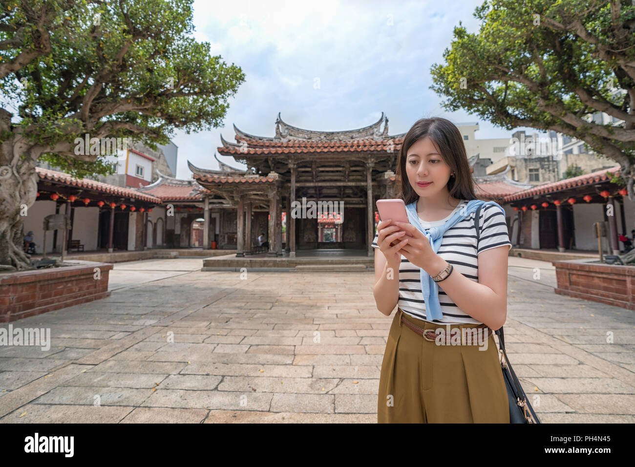 L'Asie à la recherche de quelque chose par téléphone. trouver la destination suivante Banque D'Images
