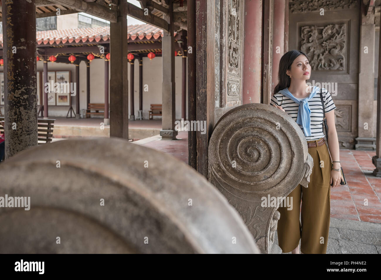Femme d'origine asiatique debout derrière de sculpture. dans le temple de lukang Banque D'Images