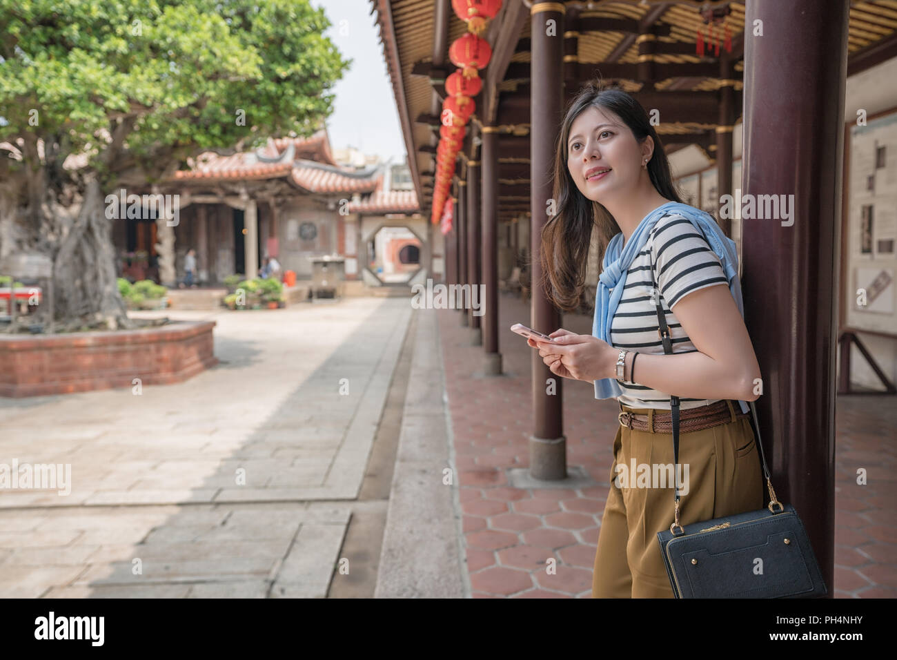 La recherche d'Asie par le téléphone. vue latérale d'une femme. Banque D'Images