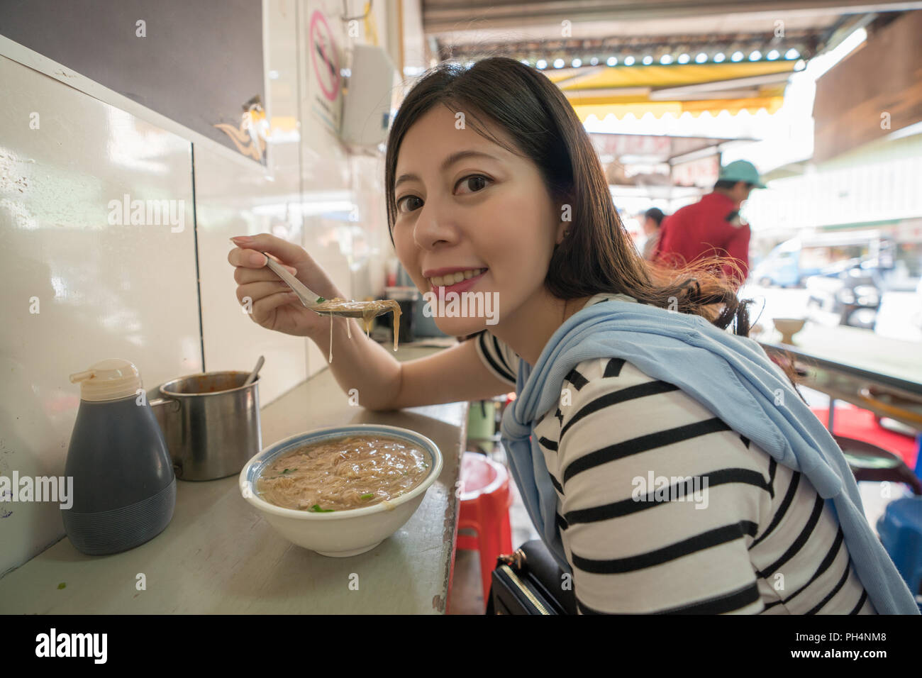 Visiteur asiatique de manger la nourriture locale. tranditinal femme ont un smiley Banque D'Images