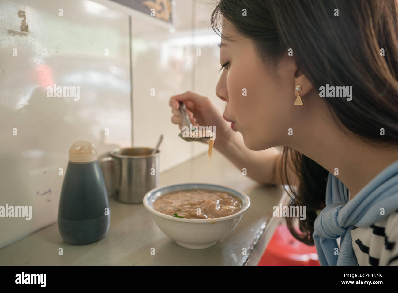 Visiteurs asiatiques essayant de manger de la nourriture chaude. un décrochage dans Old street Lukang Tianhou Banque D'Images