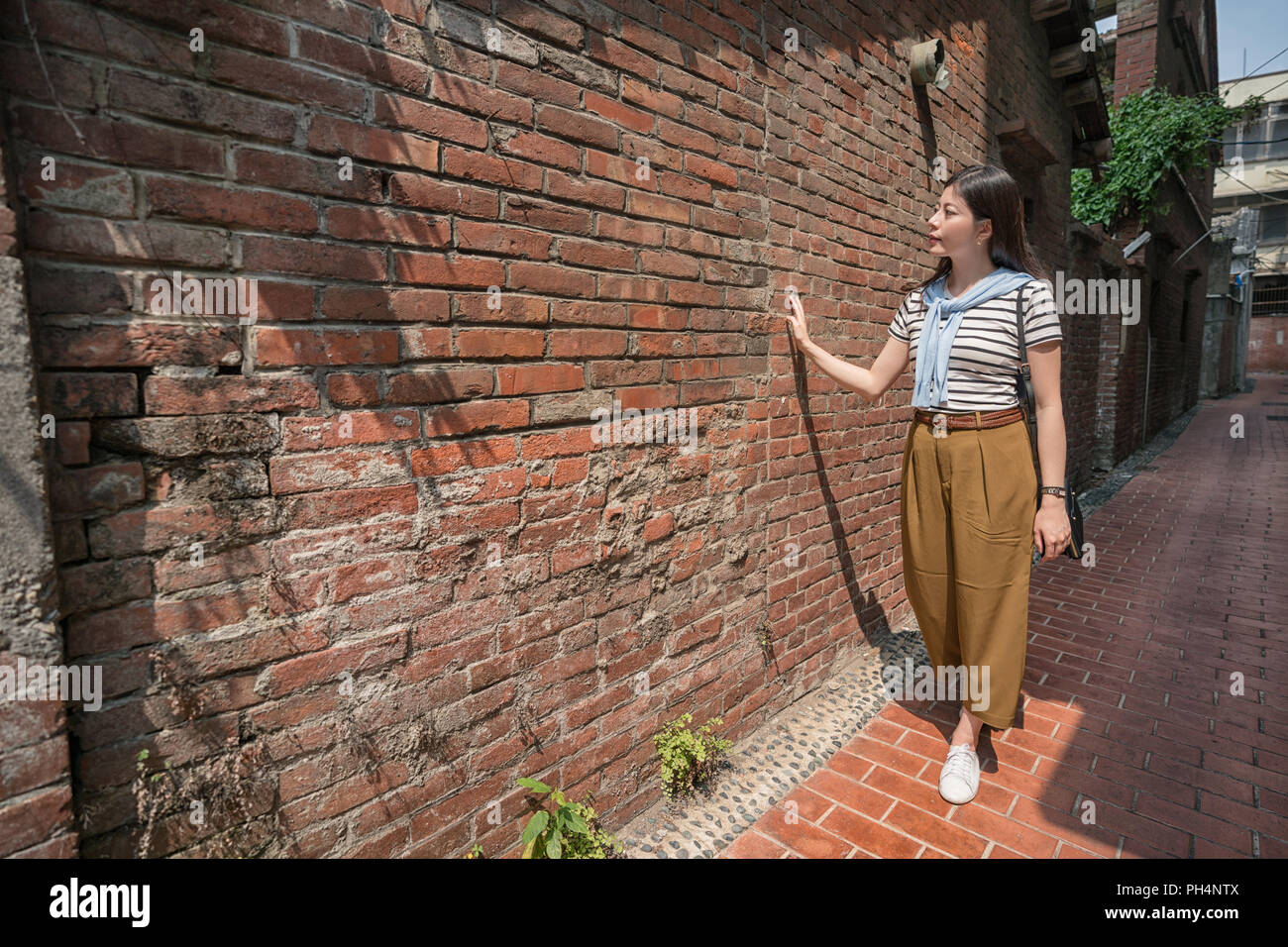 Femme d'origine asiatique marche dans la vieille rue. admirer l'ancien bâtiment. Banque D'Images