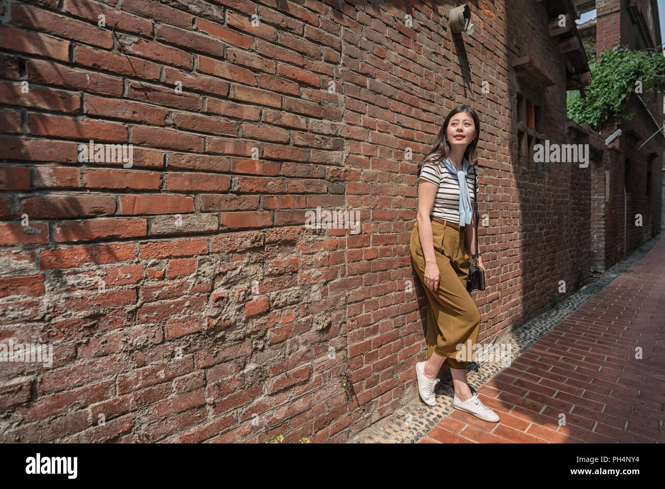 Visiteur s'appuyant sur le mur en vieille rue. une ruelle étroite dans Old street. Banque D'Images
