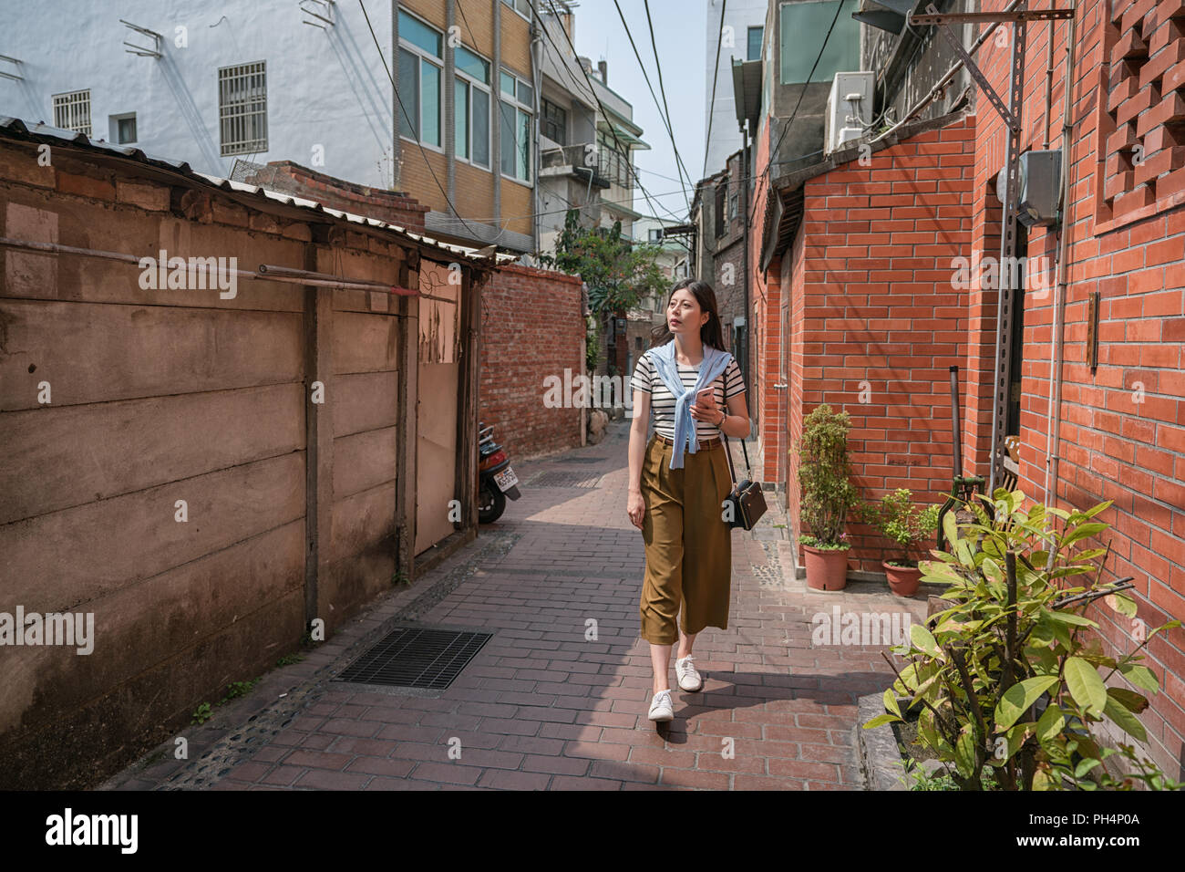 Asian woman walking dans l'étroite ruelle. entourant dans les vieilles maisons. Banque D'Images