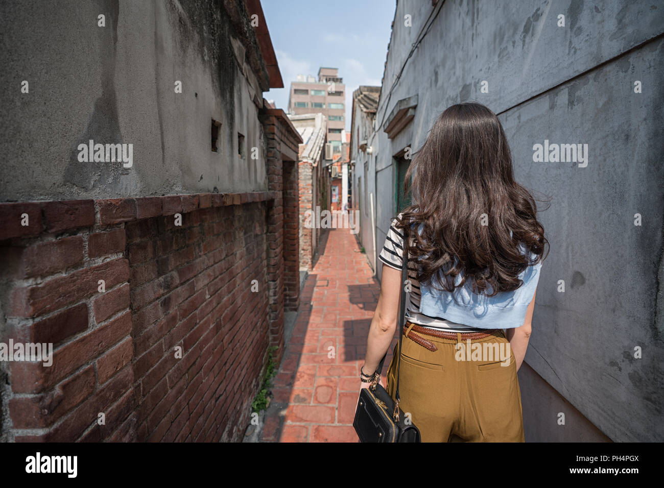 Asian woman standing dans la ruelle étroite. vue depuis l'arrière. Banque D'Images