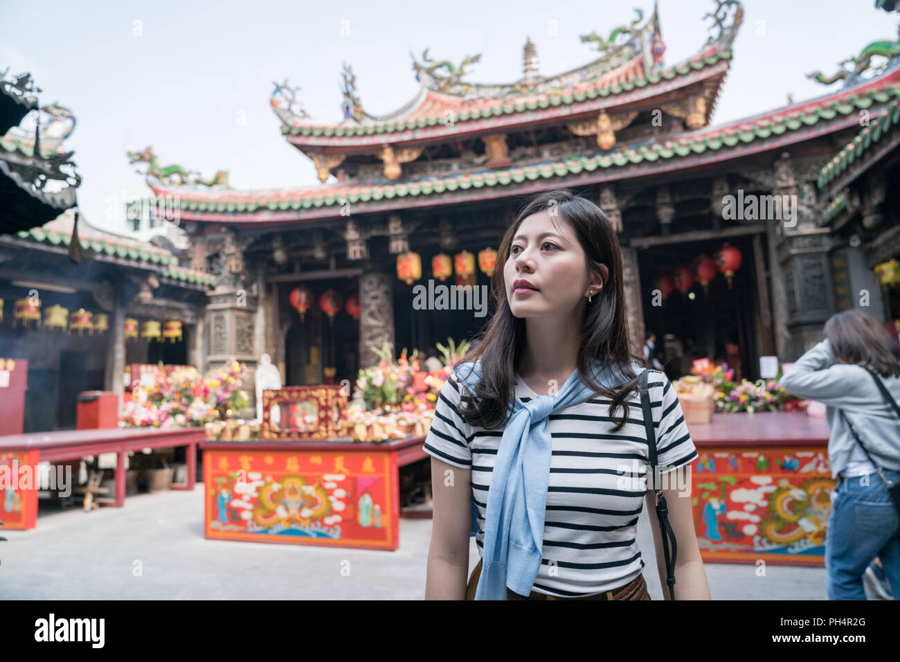 Femme Asiatique et permanent à la recherche autour du temple. Les gens d'adorer les dieux. Banque D'Images