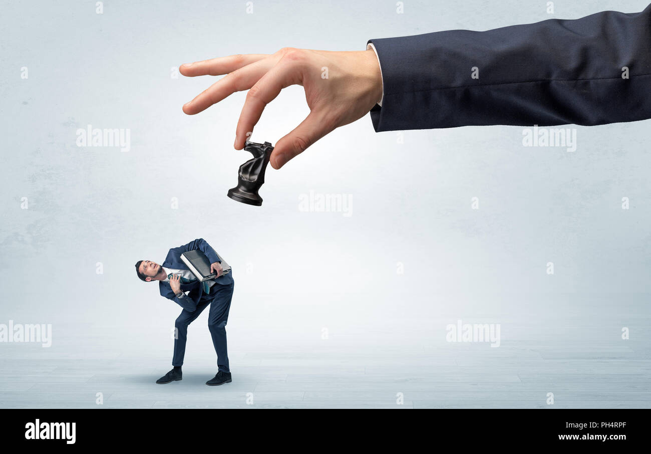 Big hand holding chessman et bas peu peur businessman concept dans un espace de lumière Banque D'Images