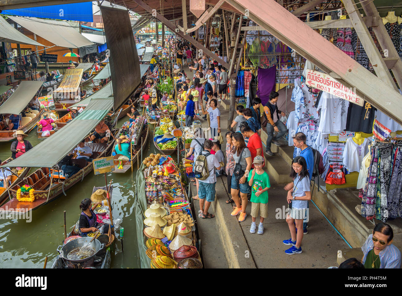 Les touristes et les vendeurs à un marché flottant en Thailande Banque D'Images