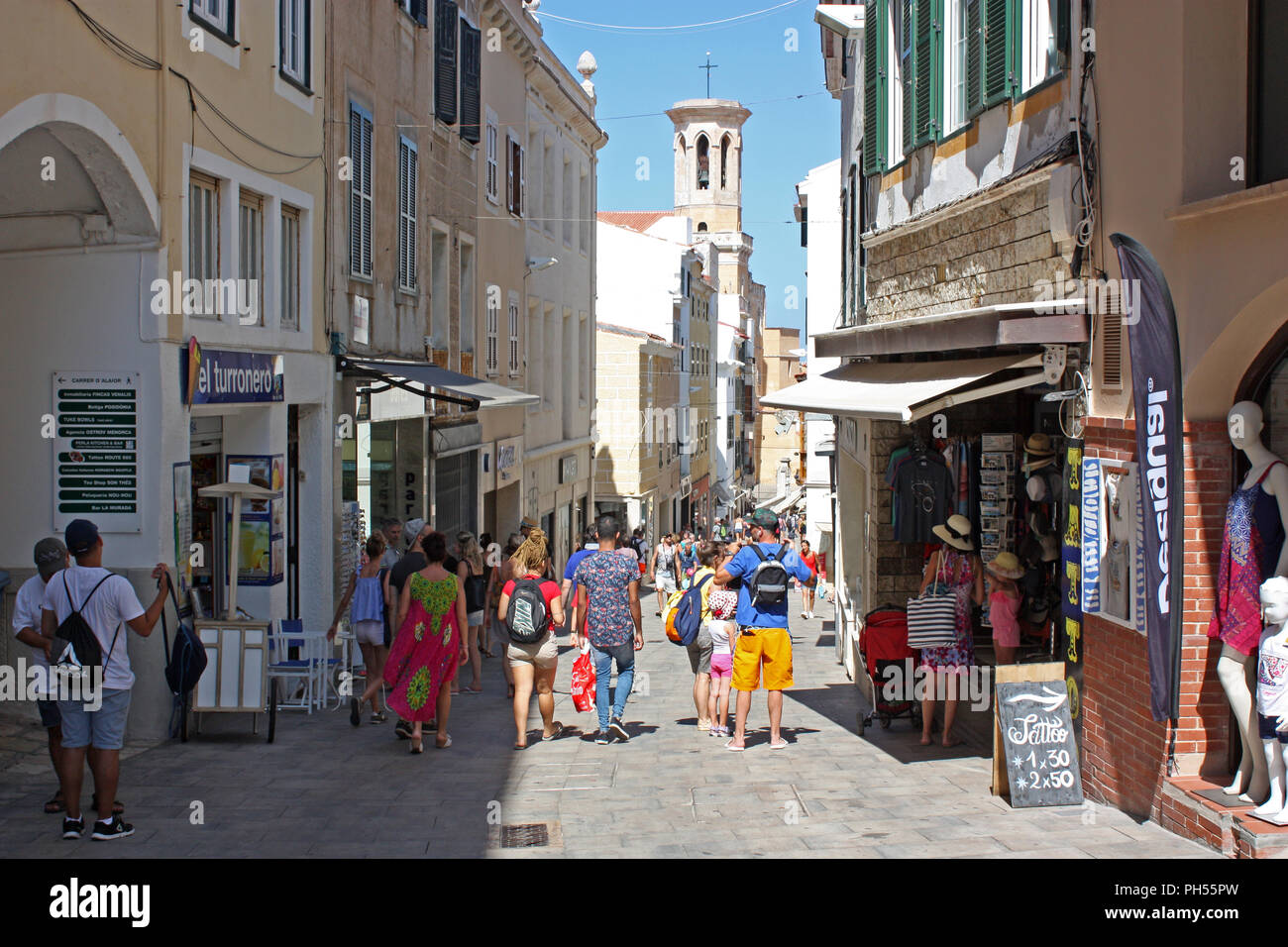 L'Espagne. Îles Baléares. Minorque. Mahon. Centre-ville. Les piétons dans la rue étroite avec clocher de la cathédrale en arrière-plan. Banque D'Images