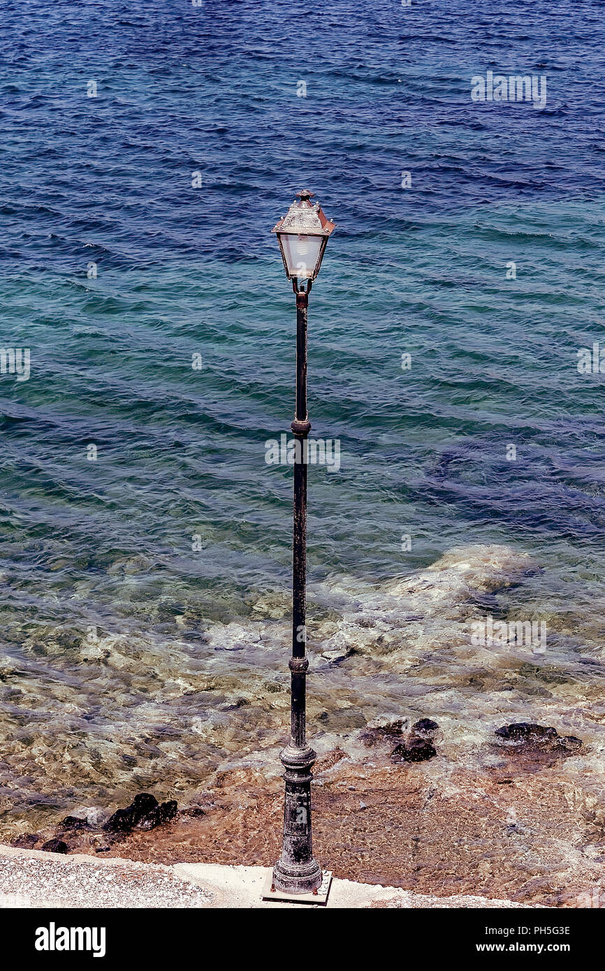 Lampe de rue sur le bord de la rue avec le bleu domine la mer en arrière-plan.. Le point de droit. Banque D'Images