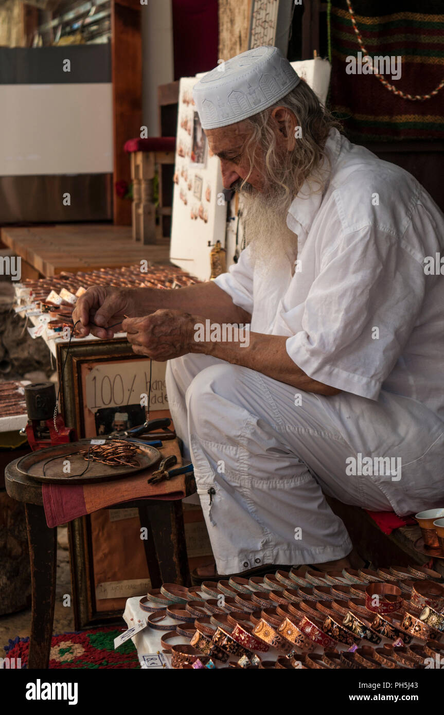 Bosnie Herzégovine, l'Europe : une vieille musulmane de Bosnie artisan portant création de bijoux vêtements traditionnelles de Bosnie dans les ruelles de la vieille ville de Mostar Banque D'Images