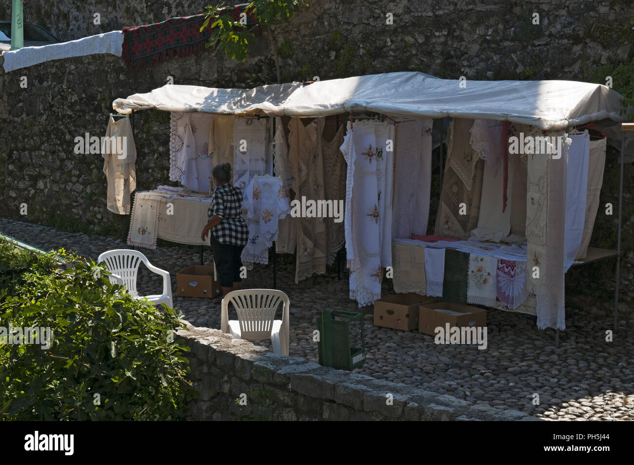 Bosnie : une vieille femme vendant des tissus brodés finement et dentelle, créé selon l'ancienne tradition des Balkans dans les ruelles de Mostar Banque D'Images