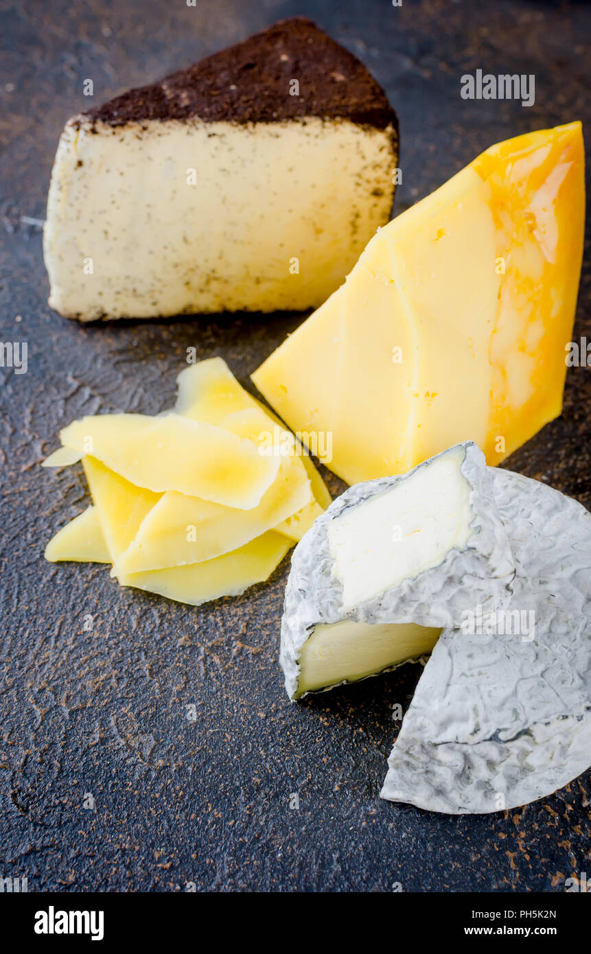 Différents types de fromages sur le plateau, assiette de fromage à partir d'un morceau de fromage à pâte dure, de fines tranches de fromage bleu, tête ronde Banque D'Images