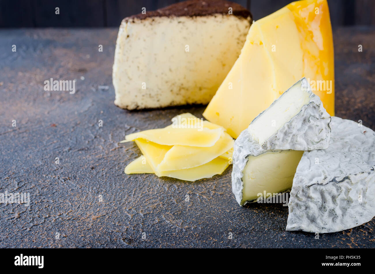 Différents types de fromages sur le plateau, assiette de fromage à partir d'un morceau de fromage à pâte dure, de fines tranches de fromage bleu, tête ronde Banque D'Images