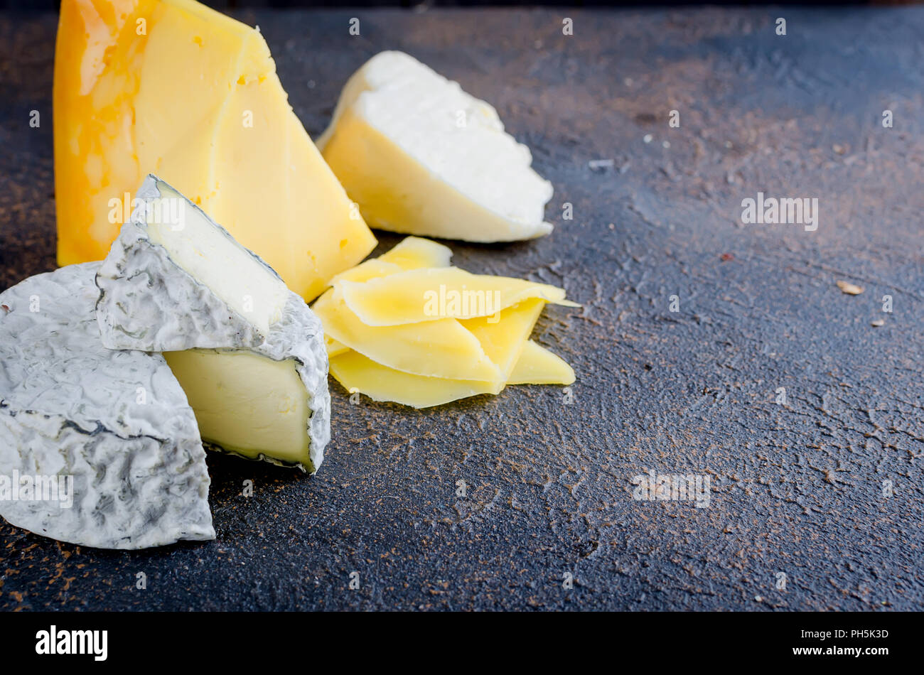 Différents types de fromages sur le plateau, assiette de fromage à partir d'un morceau de fromage à pâte dure, de fines tranches de fromage bleu, tête ronde Banque D'Images