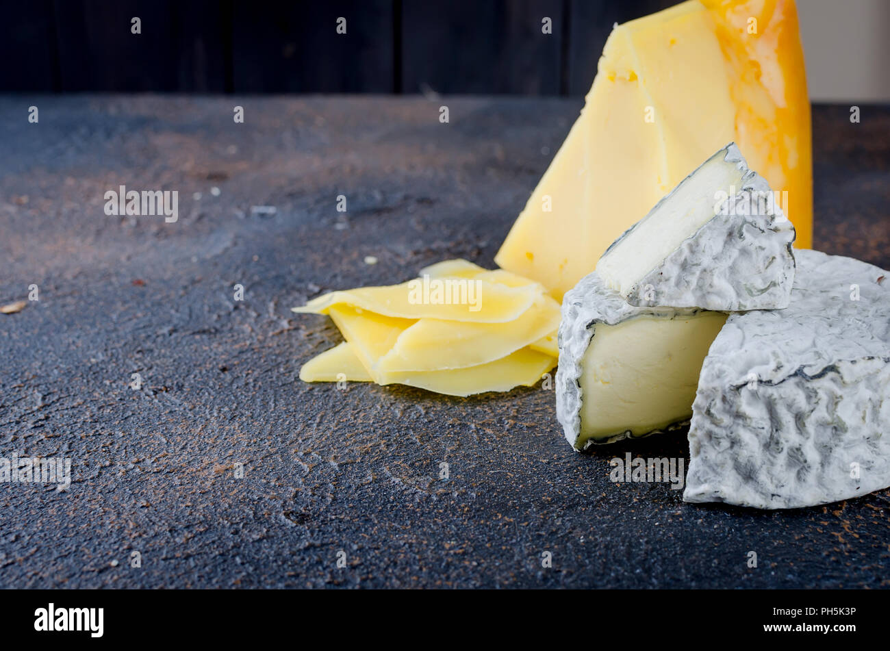 Différents types de fromages sur le plateau, assiette de fromage à partir d'un morceau de fromage à pâte dure, de fines tranches de fromage bleu, tête ronde Banque D'Images