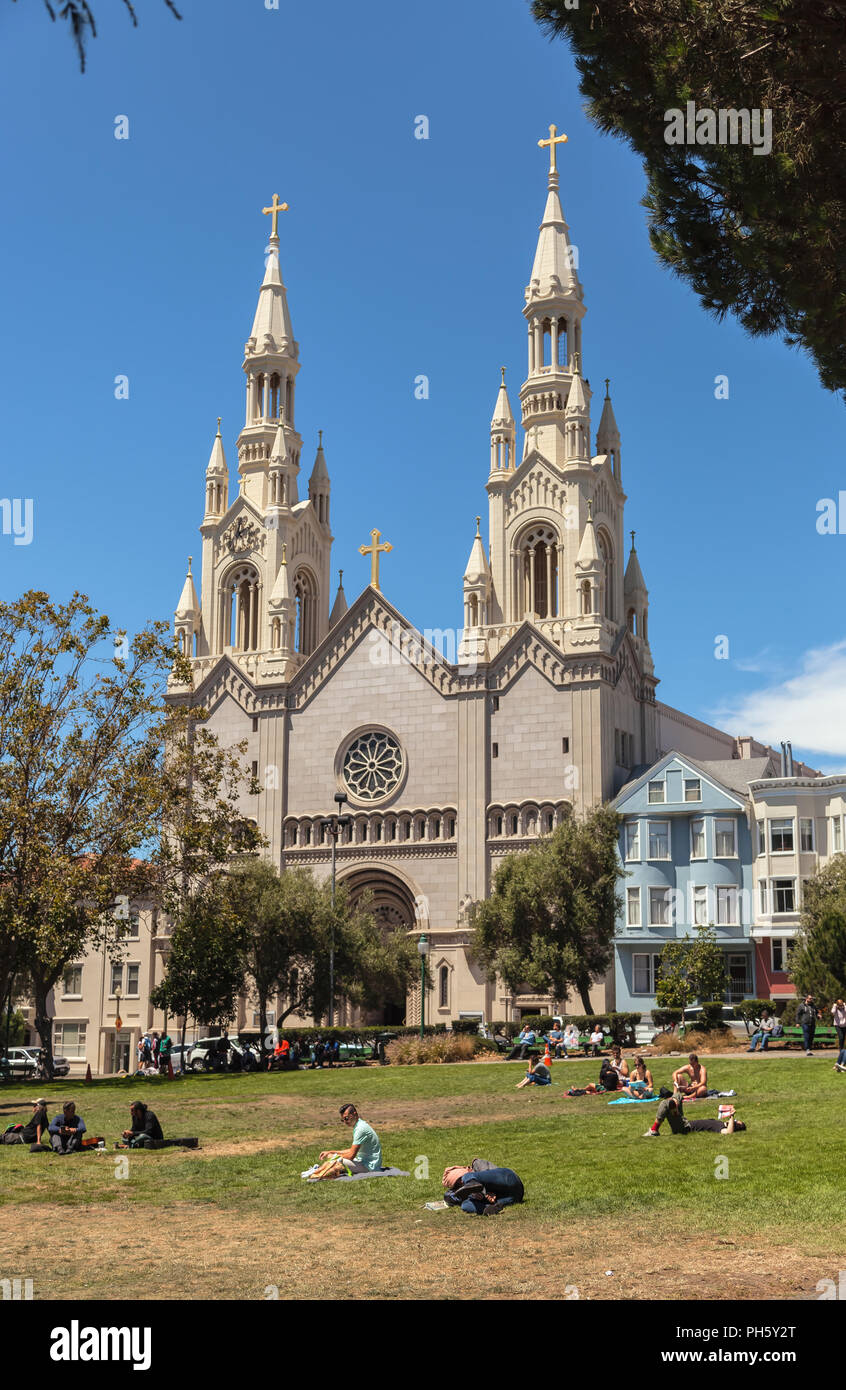 Les gens profitez d'une journée ensoleillée à Washington Square, avec la Saint Pierre et Paul Eglise catholique en arrière-plan, San Francisco, California, United States Banque D'Images