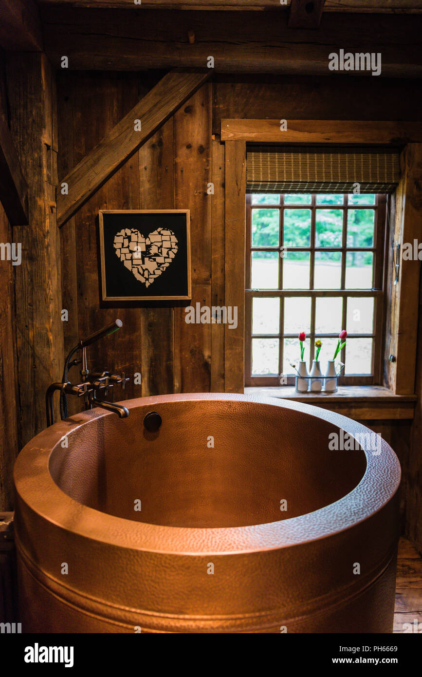 Cuivre baignoire thérapeutique japonais situé dans la région de bains rustique maison de campagne. Banque D'Images
