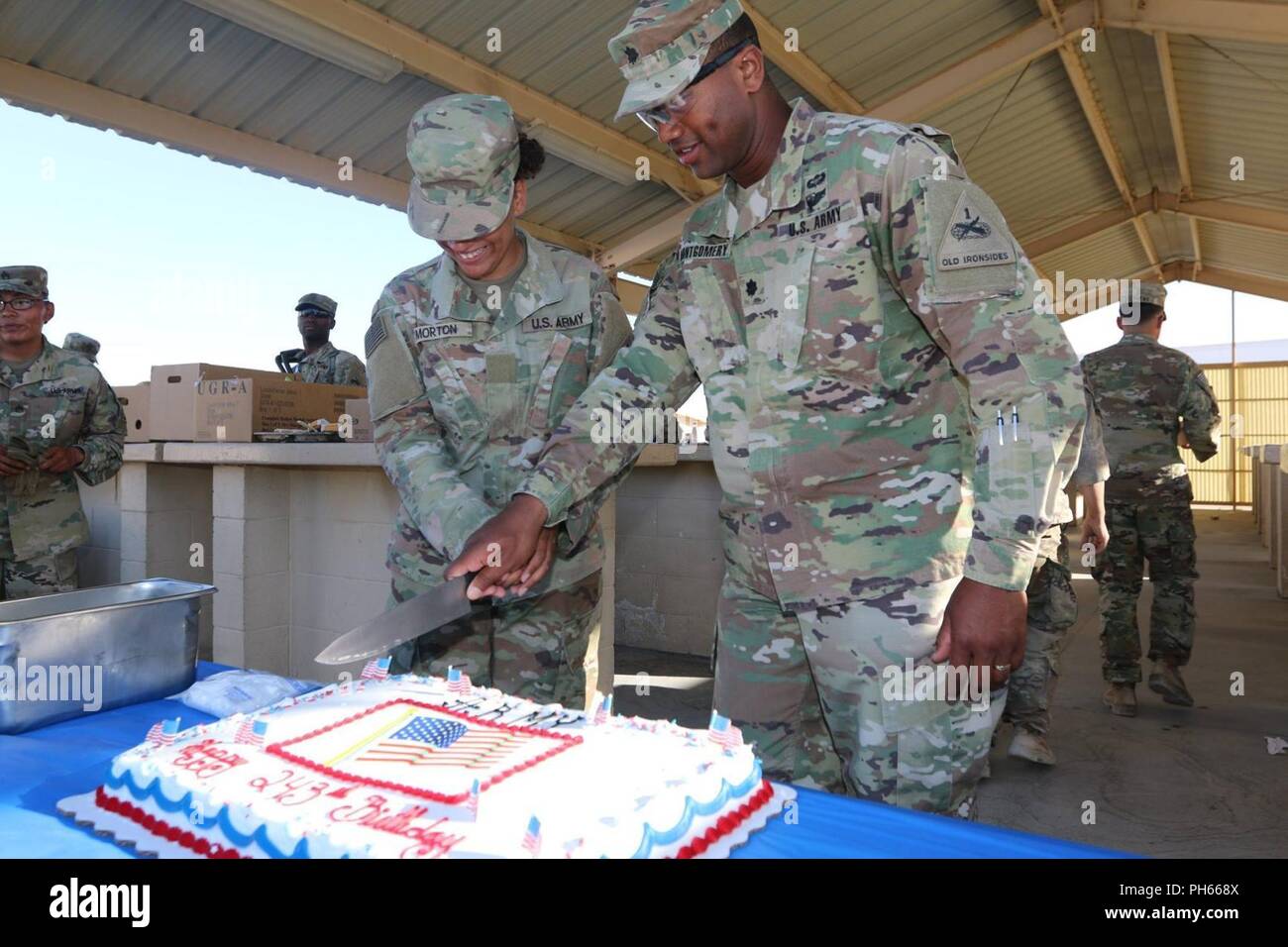 Au cours de l'anniversaire de l'Armée de terre, la 243th Bulldogs sont la formation dur dans les 'box' à Fort Irwin, en Californie. Cependant, ils ont veillé à faire respecter les traditions et les normes quelques jours plus tard avec le Lieutenant-colonel Charles Montgomery, commandant du 123e Bataillon de soutien de la Brigade, couper le gâteau avec son plus jeune soldat, Pvt. Morton. Banque D'Images