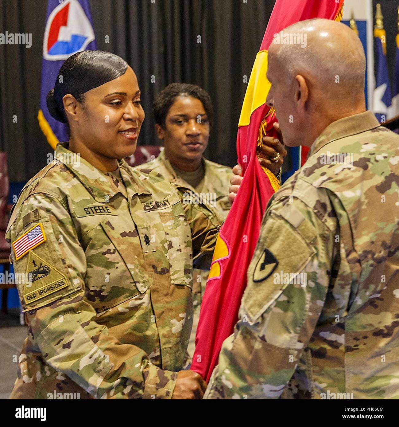 Le colonel Norbert Fochs, commandant de Blue Grass Army Depot, passe les munitions Anniston et drapeau Centre la responsabilité de l'organisation au lieutenant-colonel Roshun Steele au cours de l'ANMC Cérémonie de passation de commandement le 18 juin. L'aide à la cérémonie était le sergent de la commande. Le major Tomeka O'Neal à partir de la commande de munitions mixte. Banque D'Images