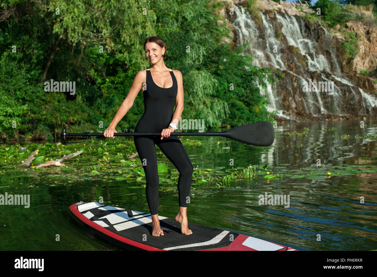 Jeune femme sportive remise en forme faire sur une carte avec une rame sur une rivière Banque D'Images