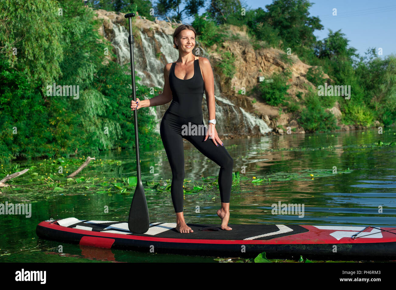 Jeune femme sportive remise en forme faire sur une carte avec une rame sur une rivière Banque D'Images