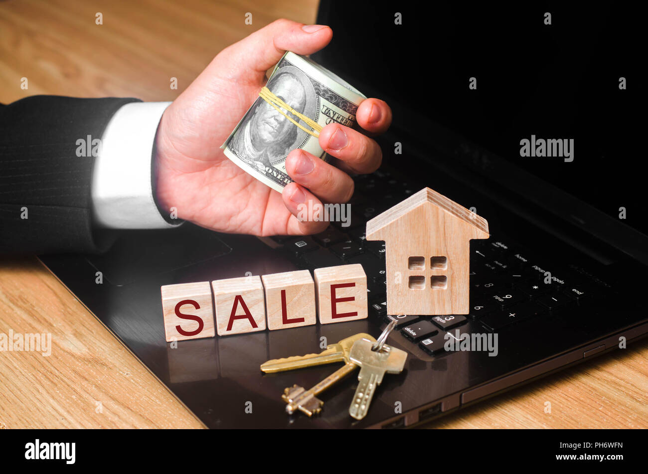 La main de l'agent immobilier est titulaire d'un tas d'argent à la maison avec les clés. Le concept de l'achat et la vente de l'immobilier, l'investissement. Estimer la valeur o Banque D'Images