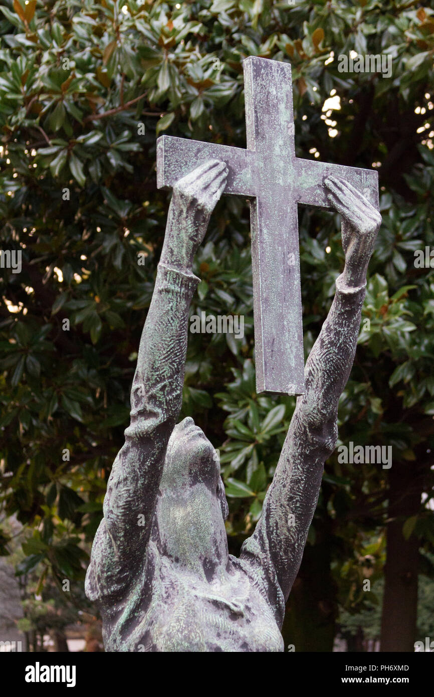 Milano, Italie. 2018/2/8. Une statue de femme tenant une croix sur une pierre tombale au Cimitero Monumentale ('Monumental' cimetière) à Milan, Italie. Banque D'Images