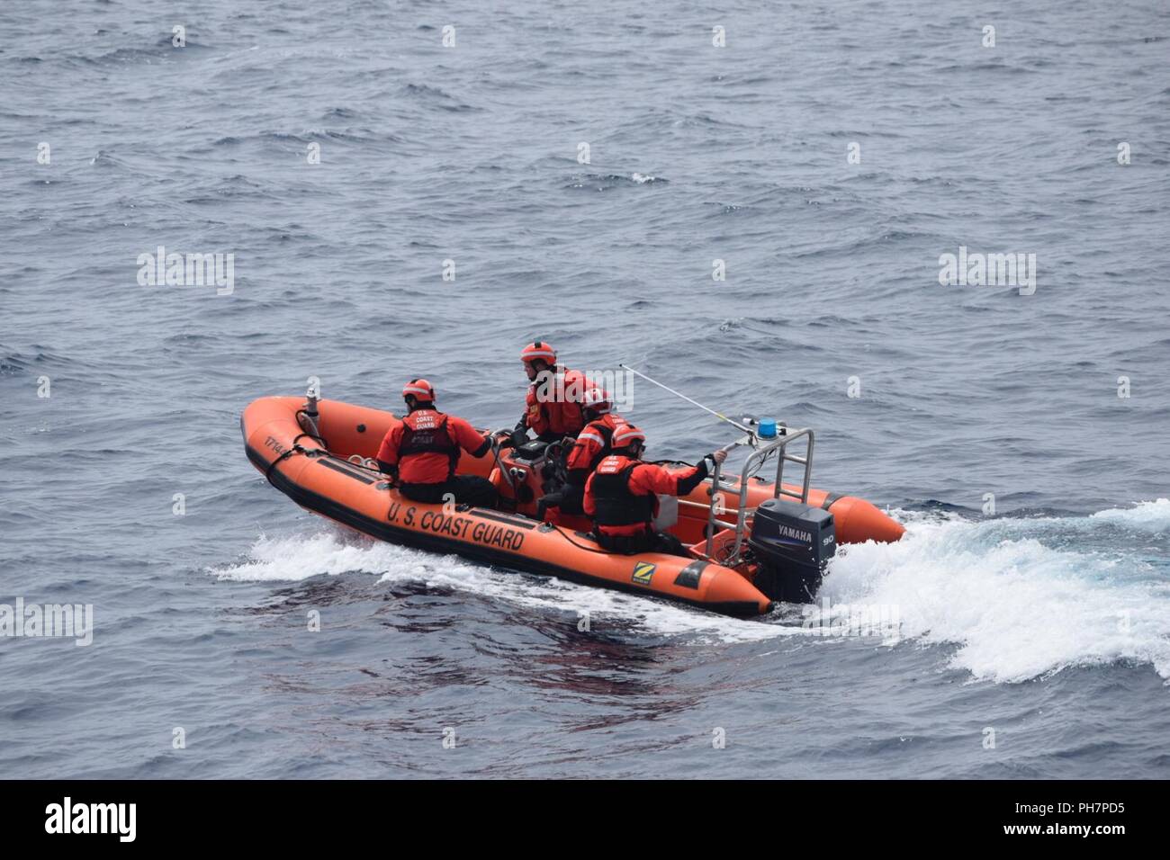 Un garde-côte de l'embarquement à bord de l'équipe d'Orcas cutter's petit bateau en direction d'un navire de pêche d'effectuer un embarquement sécurité ressources marines vivantes au cours d'une patrouille au large de la côte de l'Oregon, le 29 juin 2018. La protection des ressources marines vivantes est l'une des 11 missions de la Garde côtière. Banque D'Images