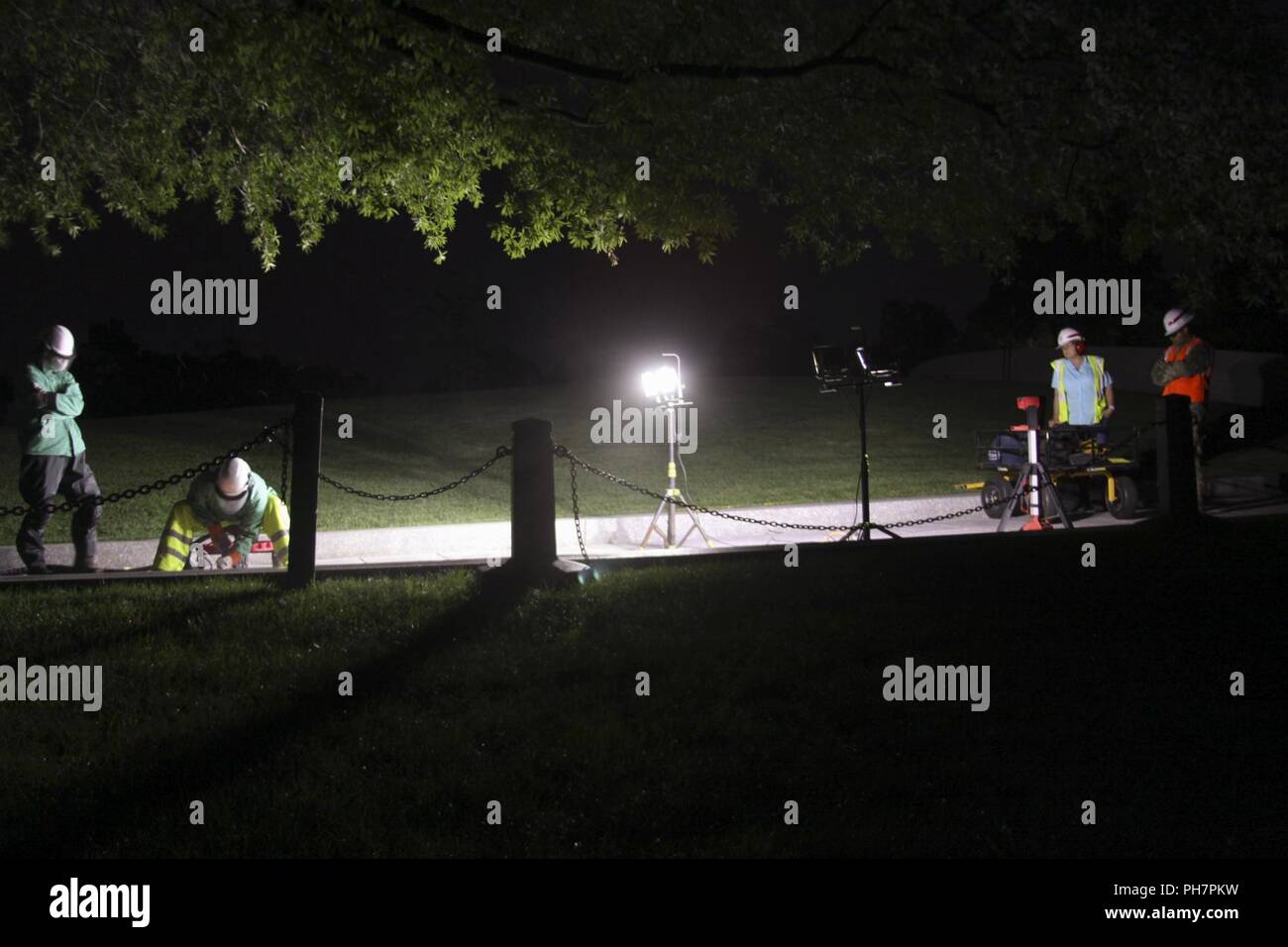 (Le Cimetière national d'Arlington) - Entrepreneurs, travaillant pour l'US Army Corps of Engineers du District de Norfolk, l'utilisation d'un traitement spécial afin de refaire la flamme de granit l'allée qui mènent au président John F. Kennedy comme site funéraire représentant Norfolk District regardez sur ici 22 Juin, 2018. La passerelle est poncé pour la rendre moins glissante lorsque mouillée, de façon à le rendre plus sûr pour les visiteurs du cimetière. Banque D'Images