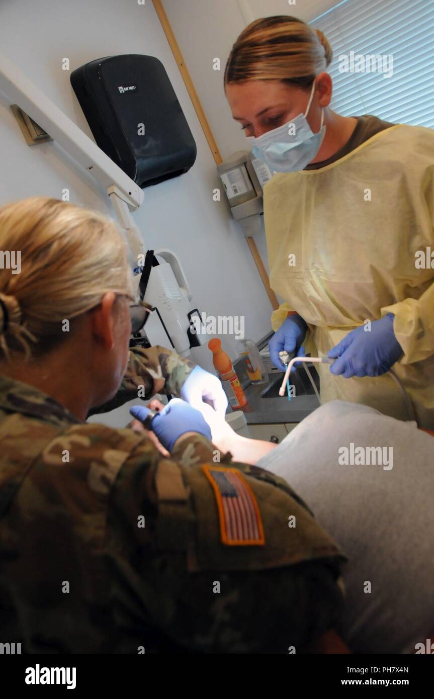 Le lieutenant-colonel Victoria Wilcox (à gauche), un adjoint au médecin, et Pvt. 1re classe Karsin Harper (à droite), un dentiste spécialiste affecté à 7215th Groupe de soutien médical, administrer une engourdir tourné en vue d'extraire une dent du résident de l'Illinois au cours de préparation à l'innovatrice (TRI) de l'Illinois du Sud-est de l'exercice de bien-être. Les services fournis par le personnel militaire est fait par le ministère de la Défense en matière d'innovation, de formation à la préparation d'un programme civil-militaire qui construit des partenariats mutuellement bénéfiques entre les collectivités des États-Unis et le DoD. Les missions de préparation et de formation sélectionné répondent soumise Banque D'Images