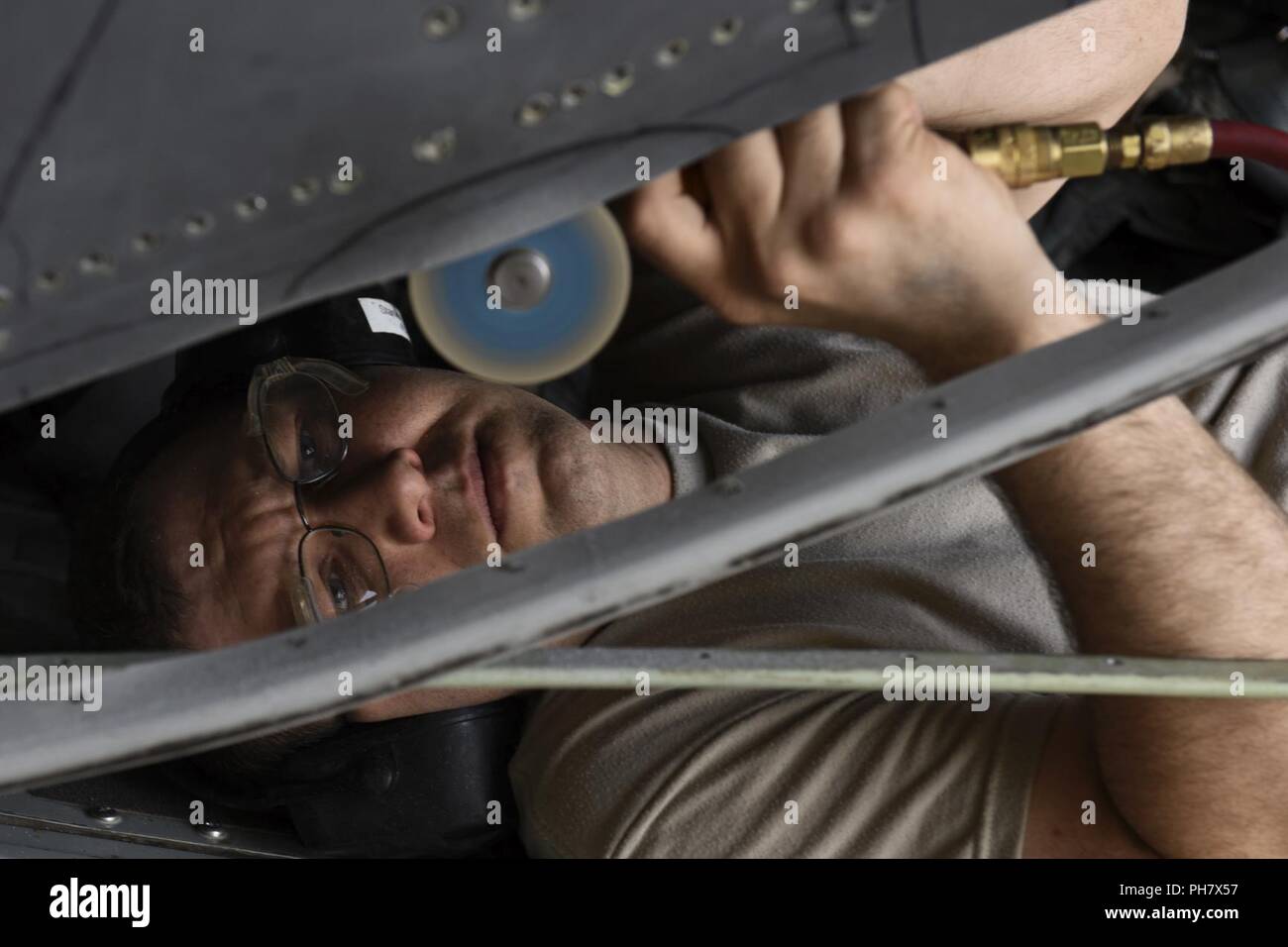 Le sergent-chef de l'US Air Force. Robert Stanley, 386e Escadron de maintenance expéditionnaire lutter contre le vol des métaux les structures d'aéronefs artisan, coupe un morceau de métal sur un EC-130H Compass Call aircraft le 30 juin 2018, dans un endroit inconnu en Asie du Sud-Ouest. La lutte contre le vol de métaux réparé une partie de l'aéronef pour être solides pour les opérations aériennes. Banque D'Images