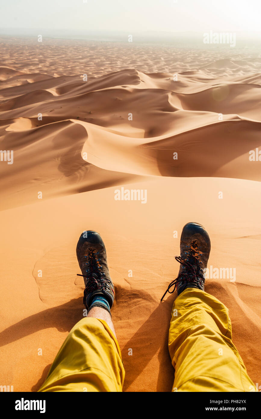 Les jambes avec des bottes de randonnée dans le sable, dune de sable, désert, l'Erg Chebbi, Merzouga, Sahara, Maroc Banque D'Images