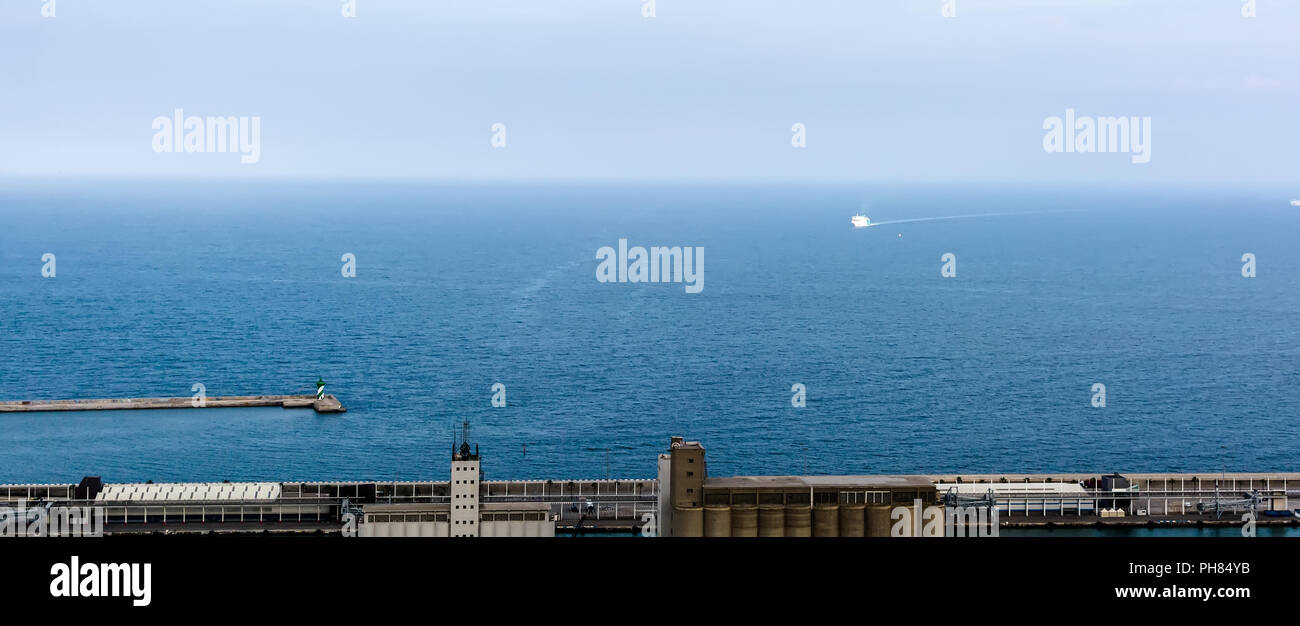 Vue aérienne sur le ferry blanc à rayures et phare dans les eaux bleues de la Méditerranée près de port industriel de Barcelone. Banque D'Images