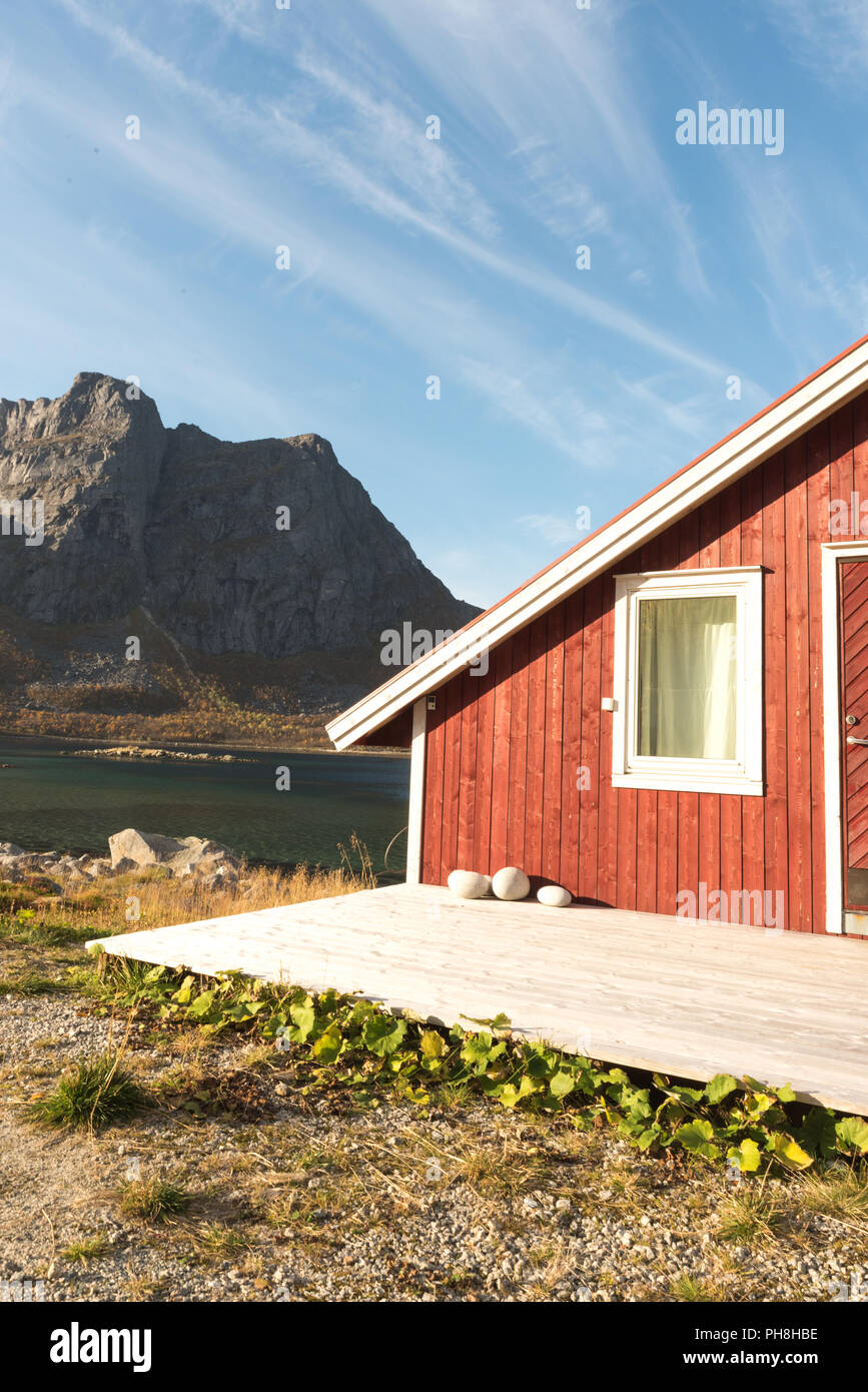 Close up portrait d'un Norvégien en bois cabane de plage avec des pierres sur le rivage avec vue sur le Fjord de Tromso, Cercle arctique, la Norvège et la montagne pe Banque D'Images