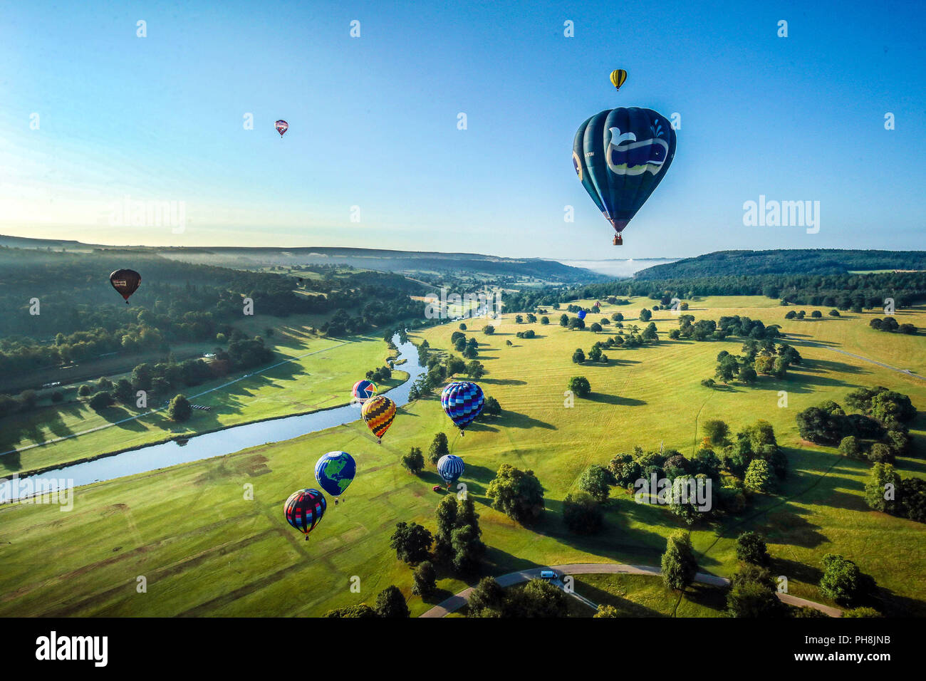 Montgolfières sur Chatsworth Park et la rivière Derwent durant la Chatsworth Country Fair de Bakewell, Derbyshire. Banque D'Images