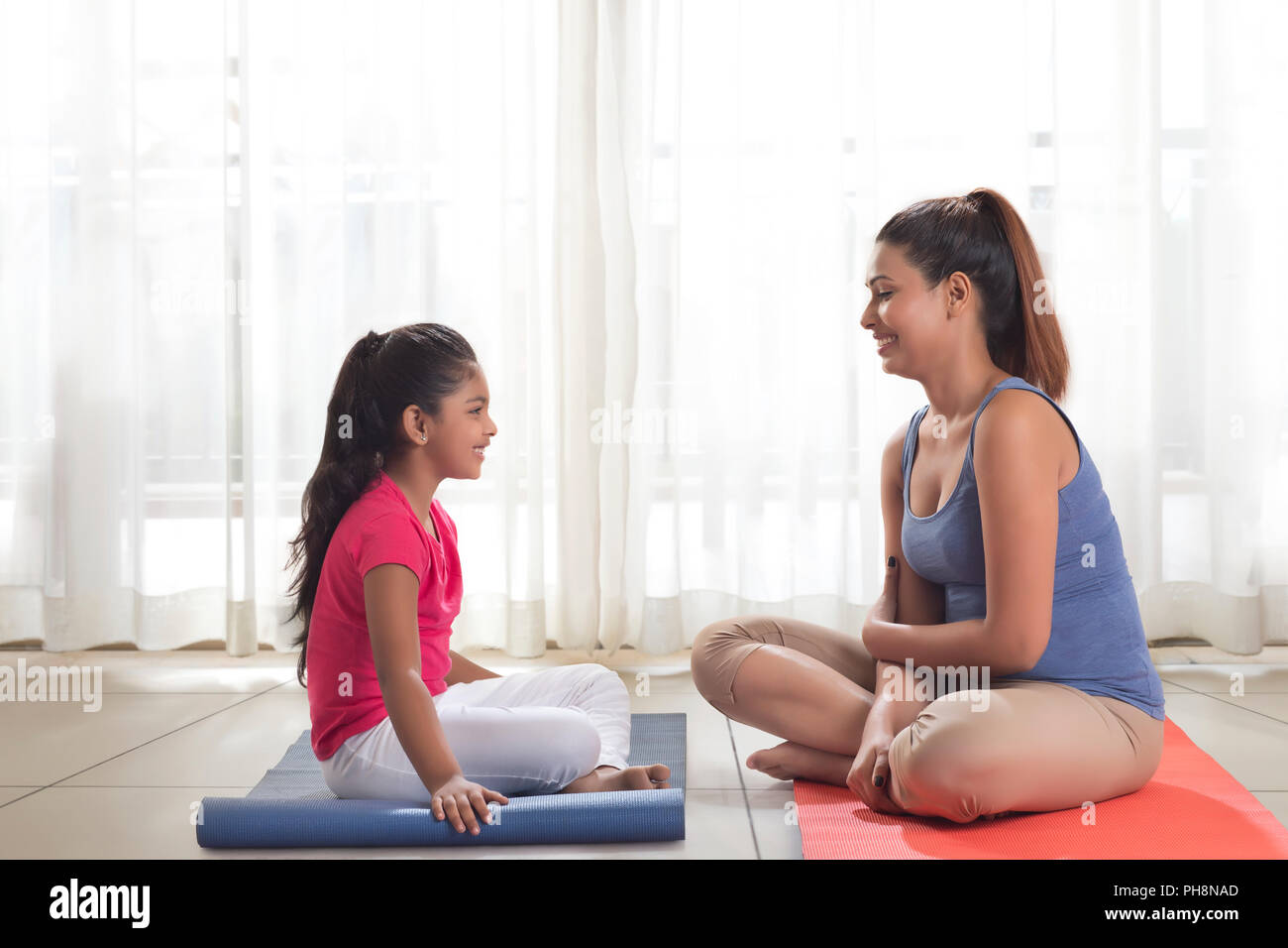 Mother and Daughter sitting on exercise mat Banque D'Images