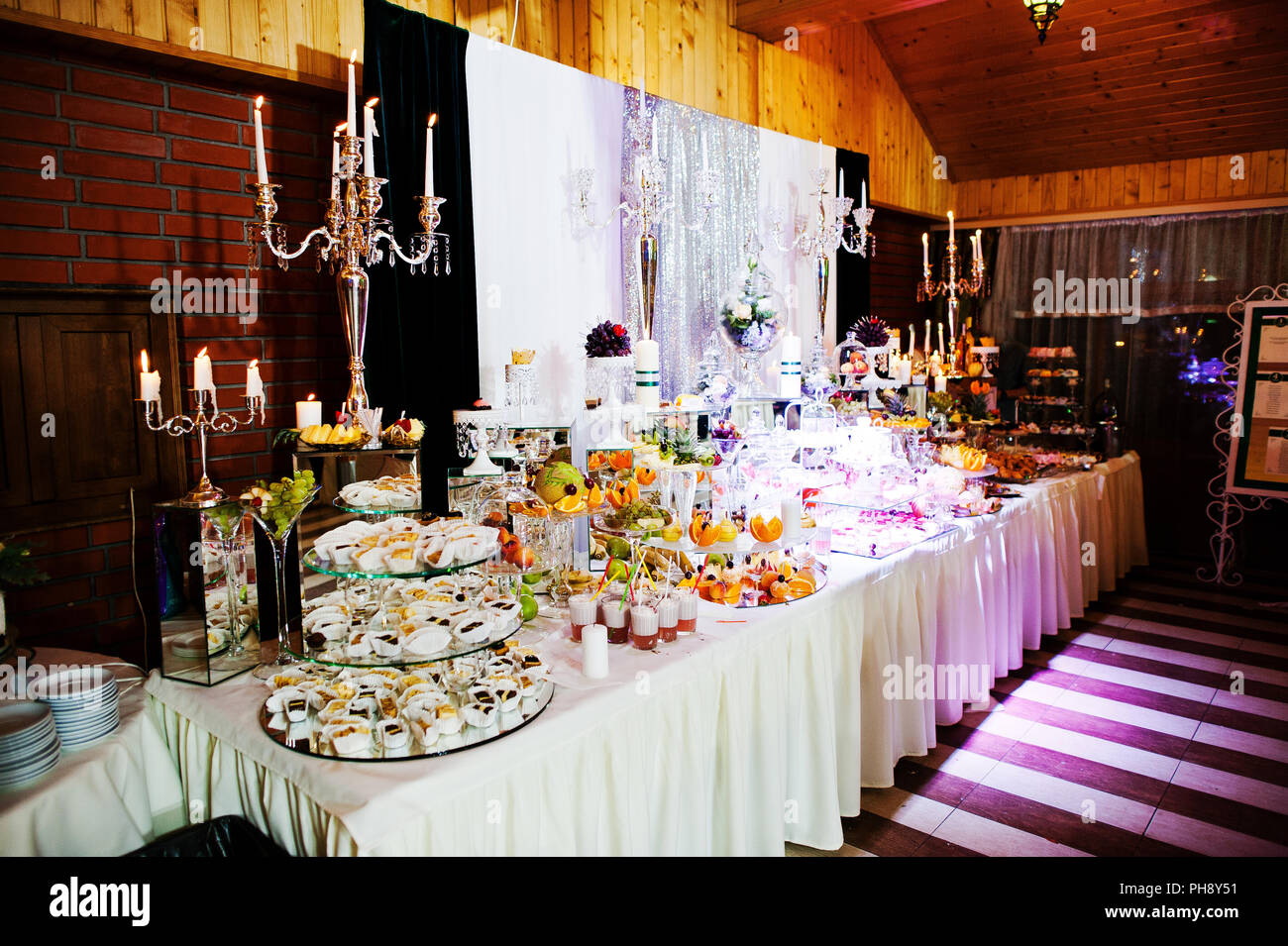 Table de réception de mariage élégance avec de la nourriture et le décor. Bougie allumée Banque D'Images